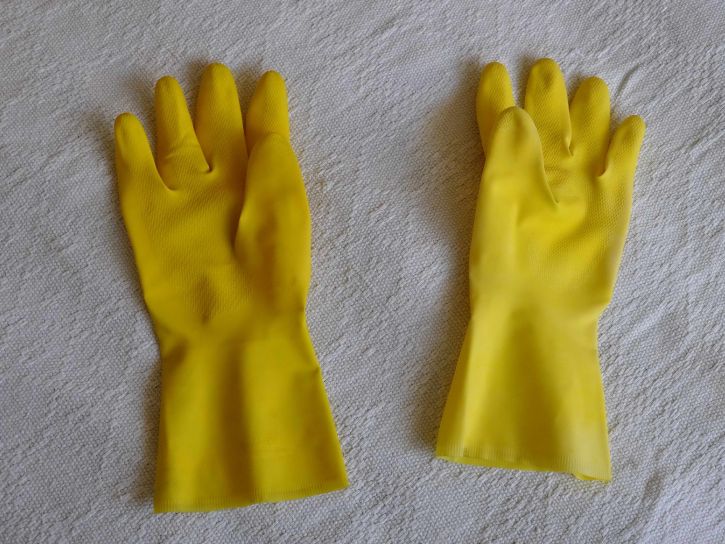 Using a rubber glove to clean pet hair from furniture